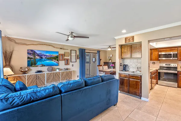 a living room with a kitchen island furniture and a flat screen tv
