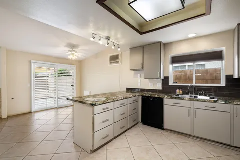 a kitchen with stainless steel appliances granite countertop a stove a sink and a refrigerator