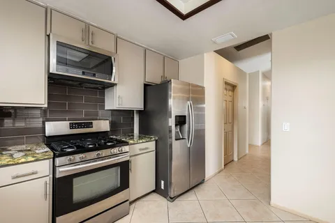 a kitchen with stainless steel appliances granite countertop a refrigerator stove and sink