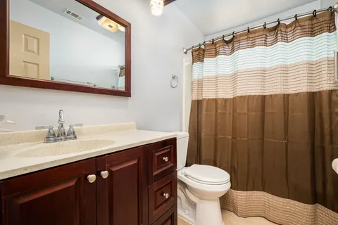 a bathroom with a sink vanity mirror and toilet