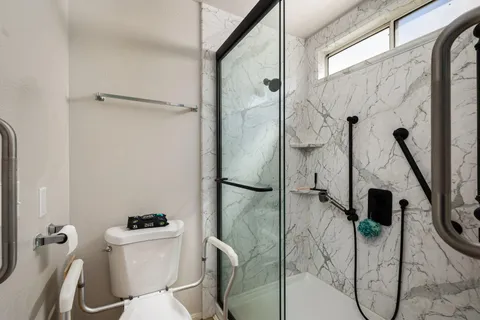 a bathroom with a toilet and a shower