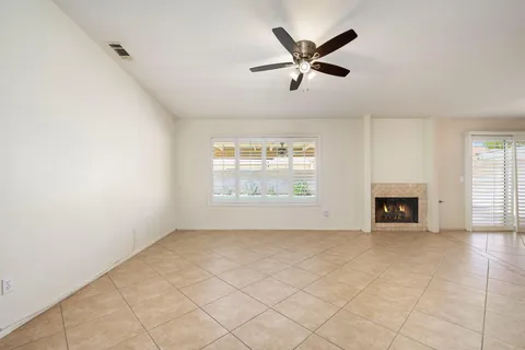 an empty room with windows and fireplace