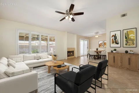 a living room with furniture a fireplace and a large window