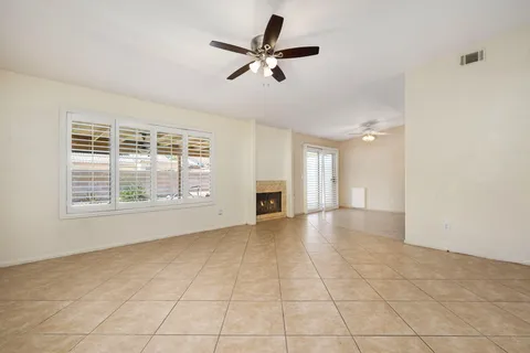 a view of an empty room with a window and a kitchen