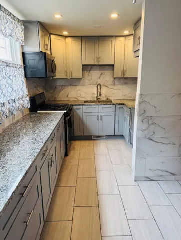 a kitchen with stainless steel appliances granite countertop a sink stove and cabinets