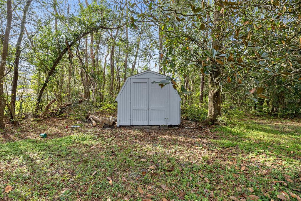 16675 Southwest 143rd Avenue Archer, FL 32618 - Photo 24 of 26 a backyard of a house with a large tree and wooden fence