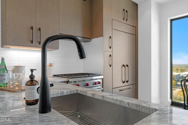 a living room with stainless steel appliances granite countertop furniture a stove a chimney and a large window