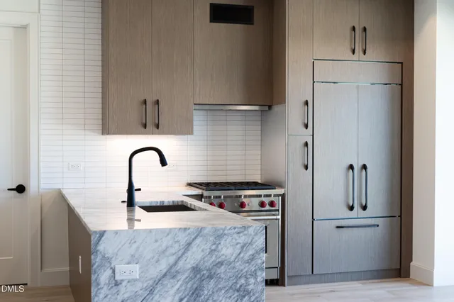 a kitchen with stainless steel appliances granite countertop a stove a sink and a refrigerator