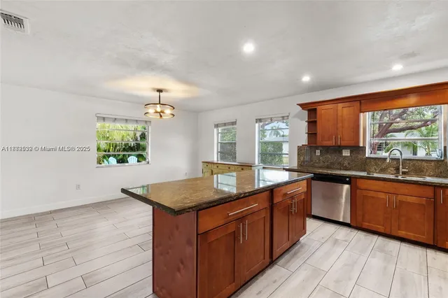 a kitchen with granite countertop a stove top oven microwave and cabinets