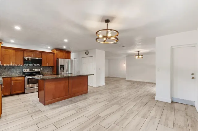 a kitchen with kitchen island granite countertop a sink and a granite counter tops