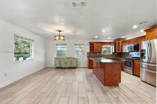 a large kitchen with stainless steel appliances granite countertop a large counter top and a stove