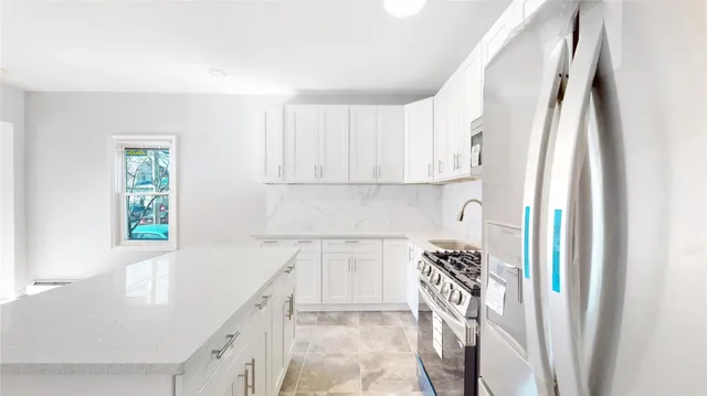 a kitchen with a refrigerator a stove top oven a sink and cabinets