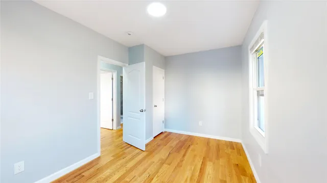 a view of empty room with wooden floor