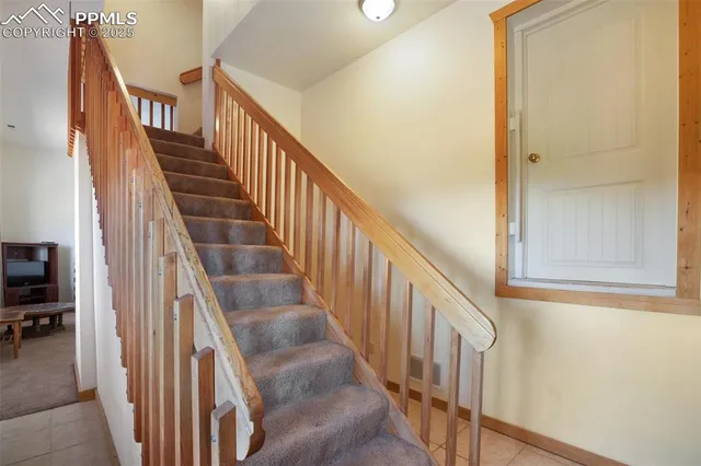 a view of staircase with wooden floor and white walls