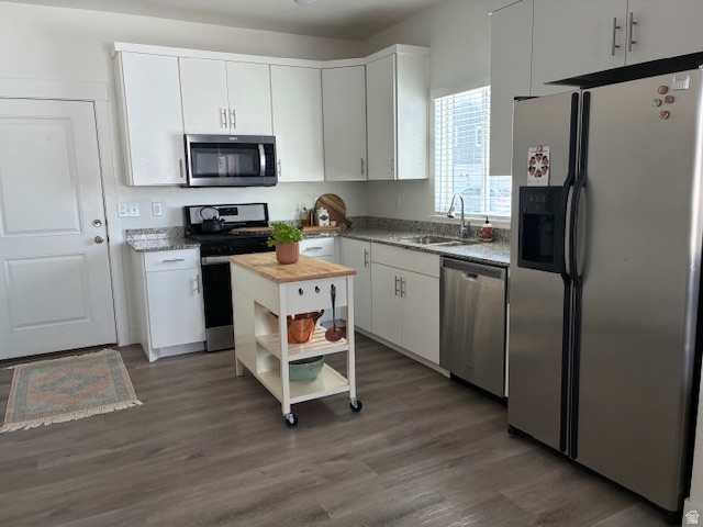 1249 West 1820th Street South Logan, UT 84321 - Photo 5 of 15 Kitchen with stainless steel appliances, white cabinetry, dark wood finished floors, and light stone countertops