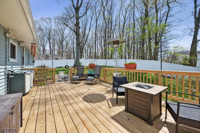 77 Brooklyn Road Stanhope, NJ 07874 - Photo 14 of 21 a view of a roof deck with table and chairs couches under an umbrella with wooden floor