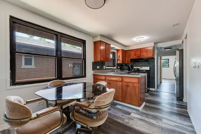 a kitchen with stainless steel appliances granite countertop a stove a sink a refrigerator white cabinets with wooden floor