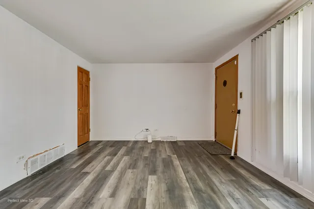 an empty room with wooden floor and a window