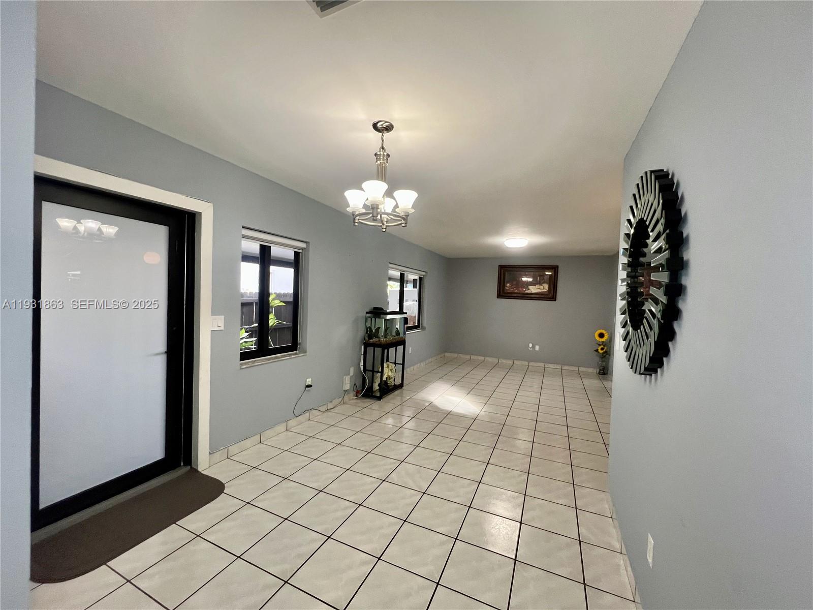 3297-3299 Southwest 26th Street Miami, FL 33133 - Photo 9 of 45 a very nice looking room with a large mirror and chandelier