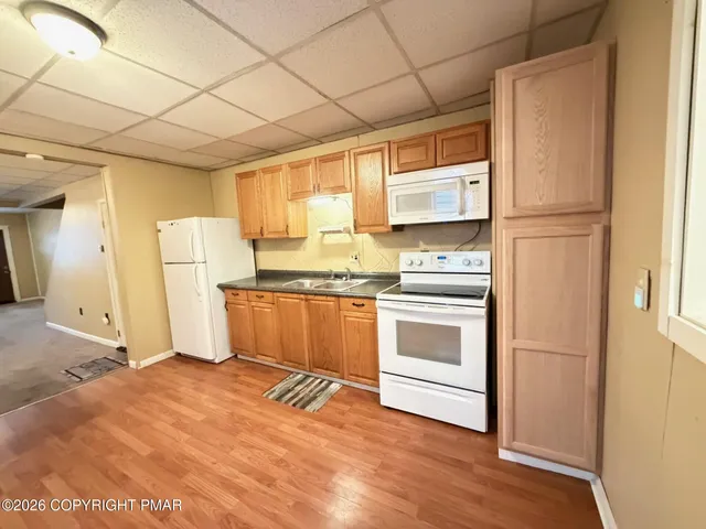 a large kitchen with stainless steel appliances kitchen island granite countertop a refrigerator and a stove top oven