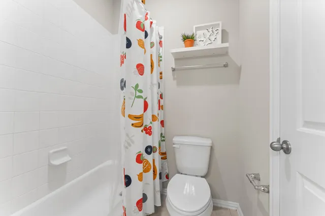 a white toilet sitting next to a white cabinet