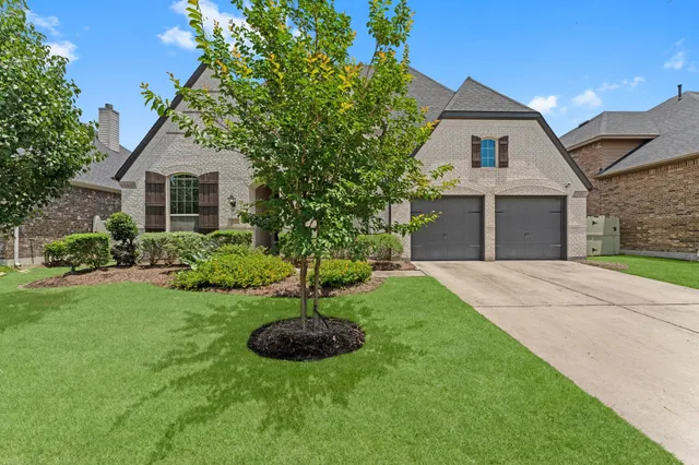 a front view of house with a garden and plants