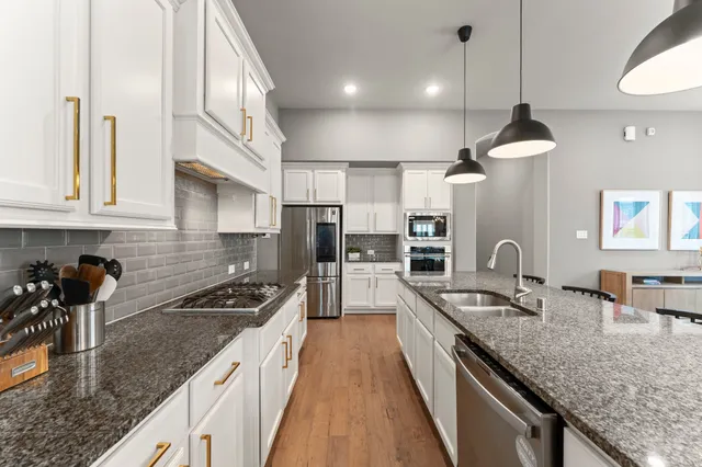 a kitchen with stainless steel appliances granite countertop a sink stove and refrigerator