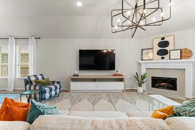 a living room with furniture a flat screen tv and a fireplace