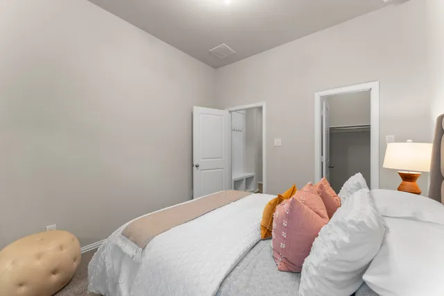 a bedroom with a bed and a lamp