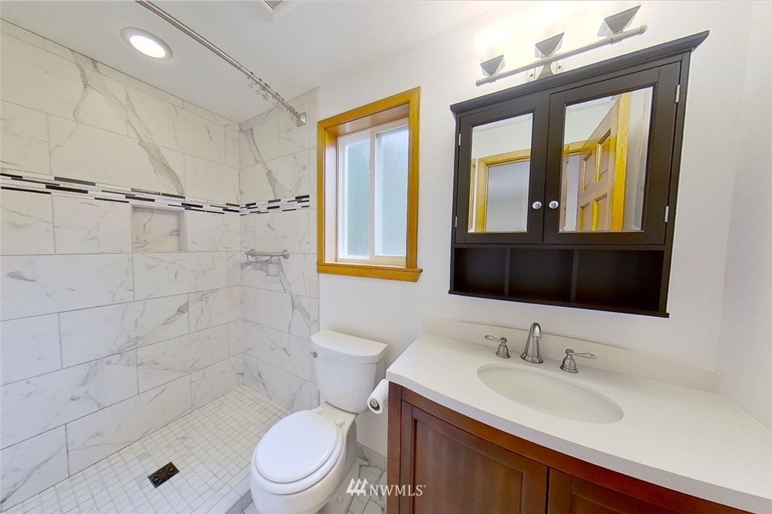 1900 Higgins Road Southeast Port Orchard, WA 98366 - Photo 12 of 26 a bathroom with a granite countertop sink toilet a mirror and shower