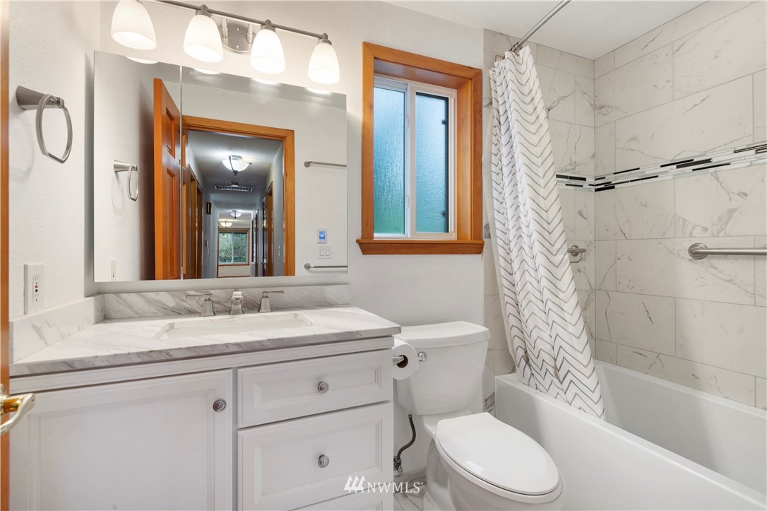 1900 Higgins Road Southeast Port Orchard, WA 98366 - Photo 15 of 26 a bathroom with a granite countertop sink toilet mirror and shower