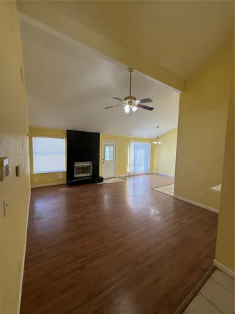 a view of a livingroom with wooden floor and a ceiling fan