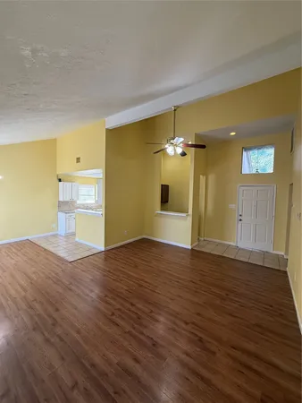 a view of empty room with wooden floor