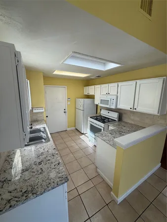 a kitchen with stainless steel appliances granite countertop a sink and a stove