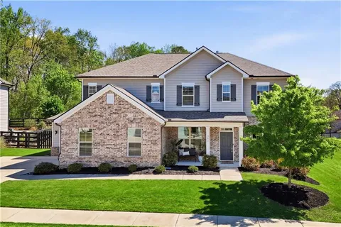 a front view of a house with a yard and green space