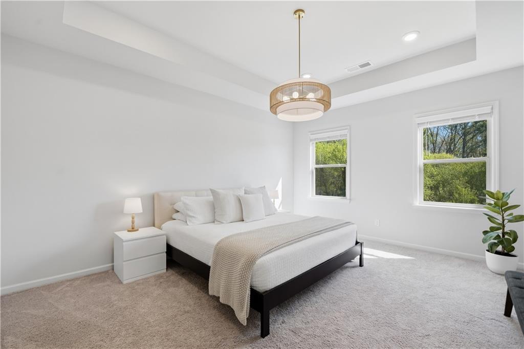 462 Carmichael Circle Canton, GA 30115 - Photo 33 of 70 a spacious bedroom with a bed and a chandelier