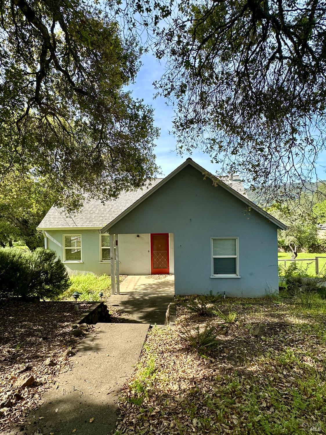 a front view of house with yard and trees around