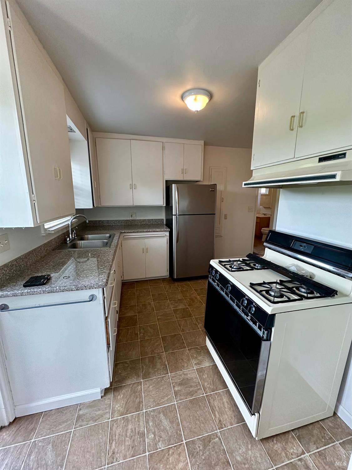 908 Sanitarium Road Deer Park, CA 94576 - Photo 5 of 14 a kitchen with a stove a sink and a refrigerator