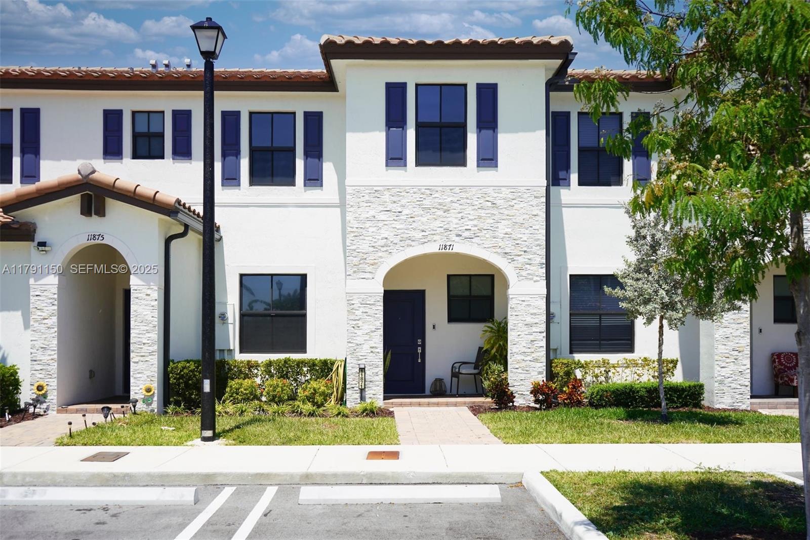 a front view of a house with yard and green space