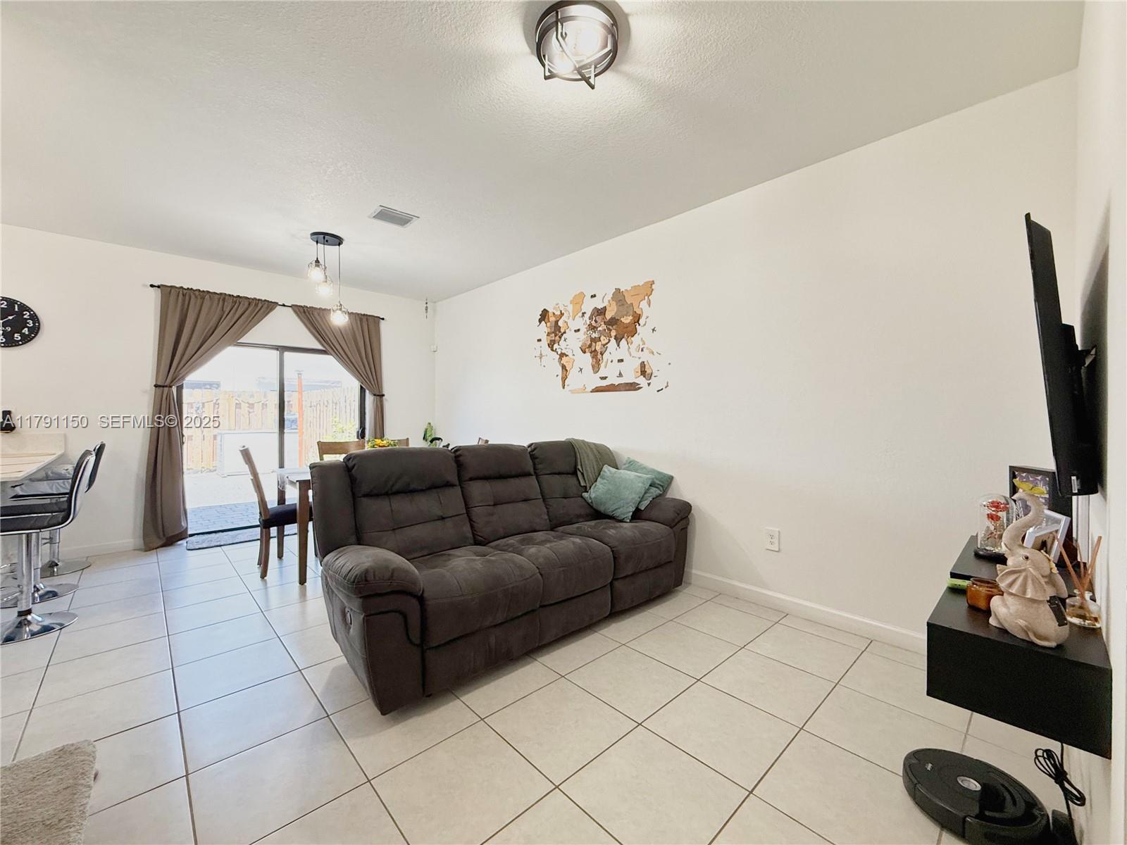 11871 Southwest 247th Terrace Homestead, FL 33032 - Photo 8 of 23 a living room with furniture and a flat screen tv