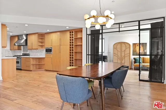a dining room filled chandelier and wooden floor