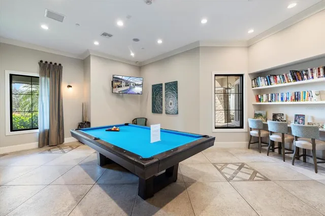 a living room with pool table and a bookshelf