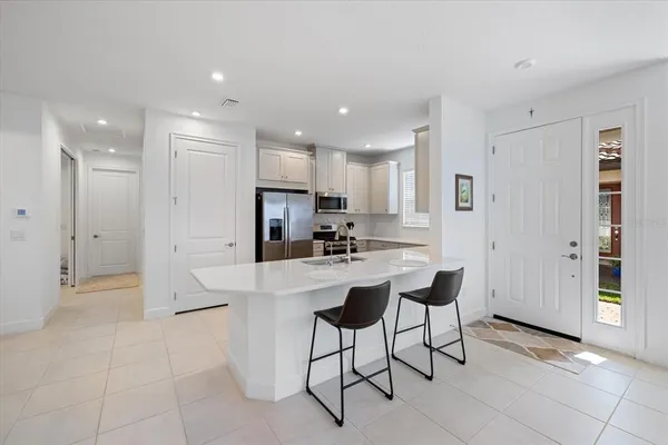 a kitchen with stainless steel appliances kitchen island granite countertop a refrigerator and a stove top oven