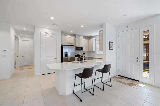 a kitchen with stainless steel appliances kitchen island granite countertop a refrigerator and a stove top oven