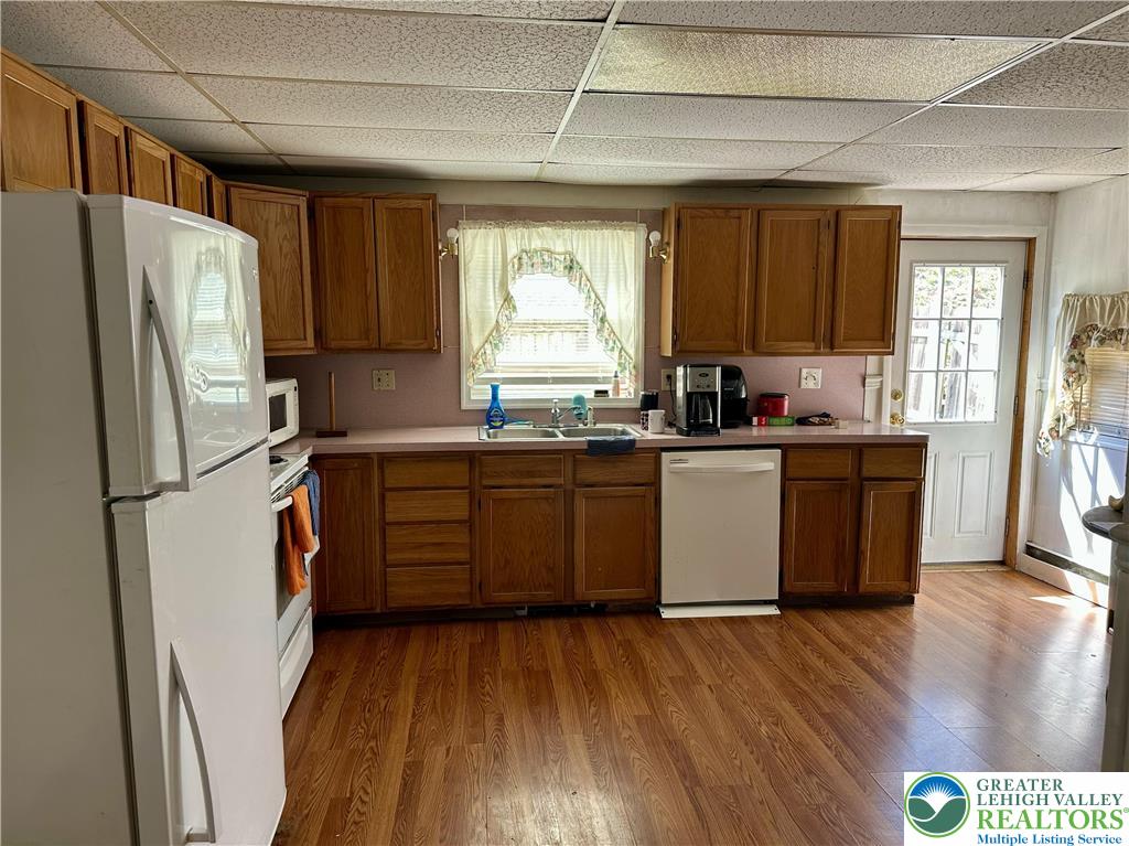 214 South Walnut Street Slatington, PA 18080 - Photo 8 of 19 a kitchen with stainless steel appliances a refrigerator a sink a stove and white cabinets with wooden floor