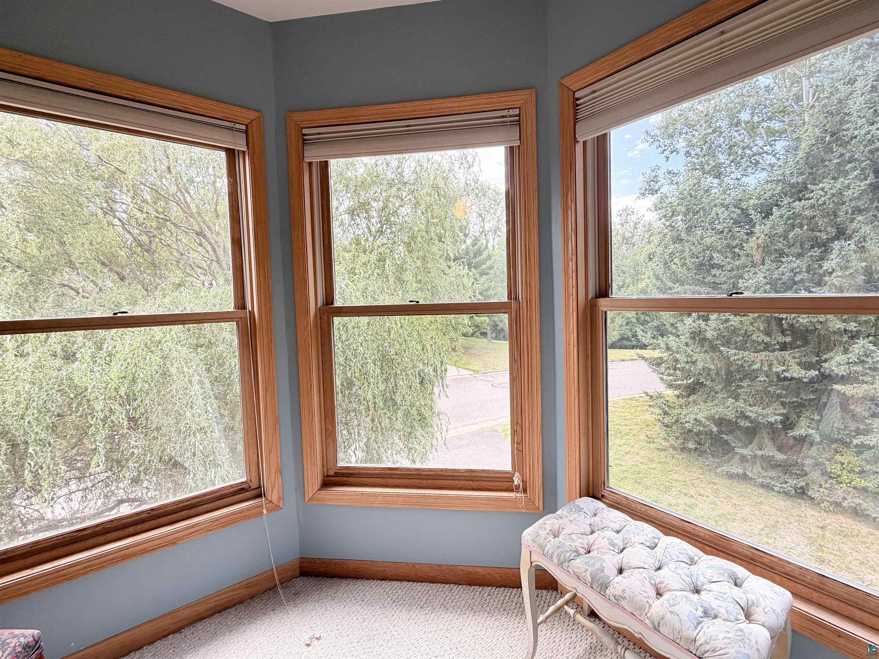 109 Prentice Heights Road, Unit 2 Ashland, WI 54806 - Photo 14 of 23 Bay window with three double-hung windows, natural wood-finish trim, and light blue wall color