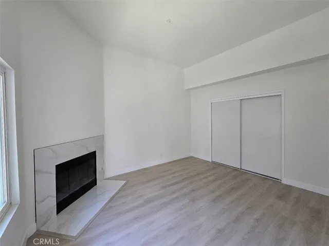 a view of empty room with wooden floor and fireplace