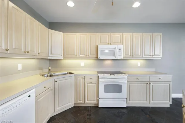 a kitchen with white cabinets and white appliances
