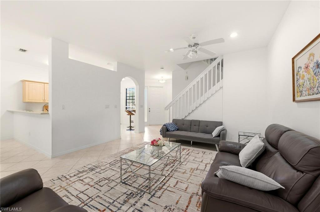Living area featuring stairway, arched walkways, light tile patterned floors, a ceiling fan, and recessed lighting