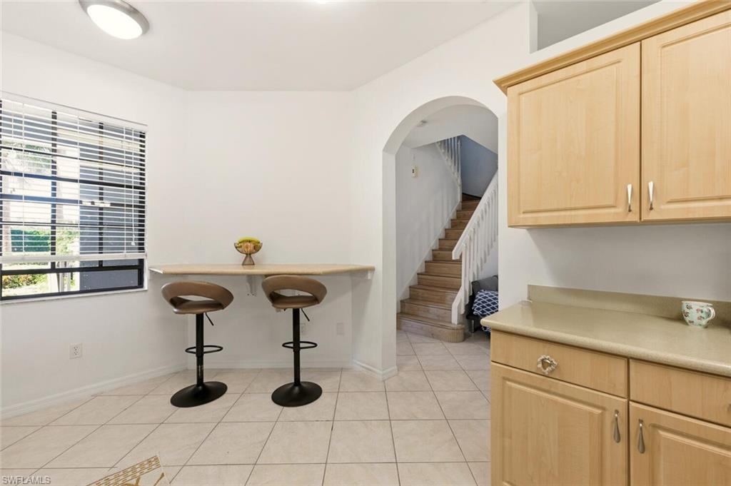 14978 Summit Pl Circle Naples, FL 34119 - Photo 12 of 35 Unfurnished dining area featuring light tile patterned flooring and stairs